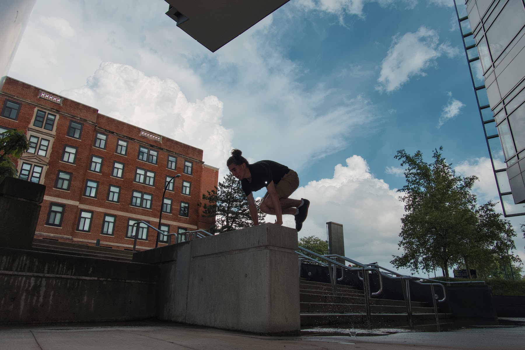 Michigan Parkour member jumping onto a concrete block under a cloudy sky