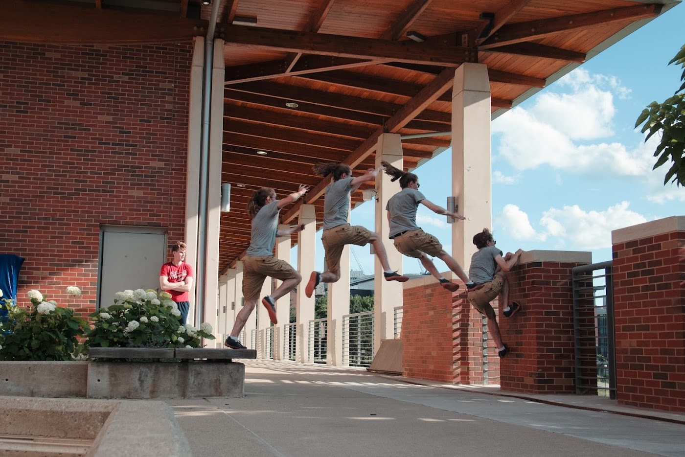 Michigan Parkour members jumping together under a campus overhang